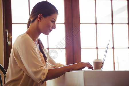 妇女使用笔记本电脑女性餐厅饮料桌子服务器酒店女士客户行业零售背景图片