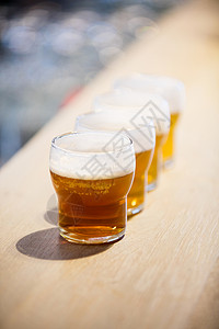 柜台上的啤酒杯贴上商业玻璃食品零售取样夜生活酒店啤酒酒精酒吧背景图片