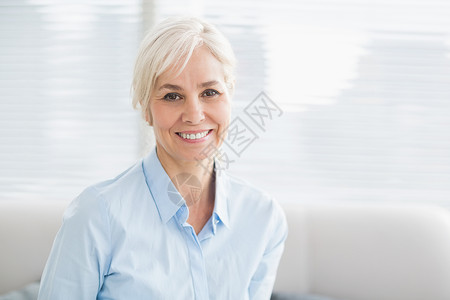 微笑的老女人的肖像沙发家庭生活退休女性房子休闲服装公寓幸福老年人背景图片