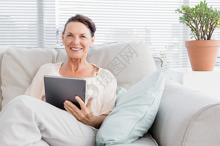 拥有数字平板电脑的快乐成年妇女的肖像背景图片