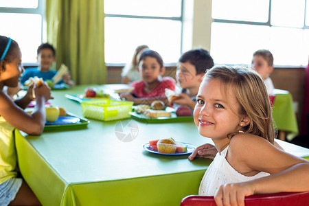 坐着吃饭的女孩和同学一起吃饭的可爱女孩背景