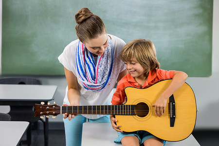 老师助学男孩弹吉他背景图片