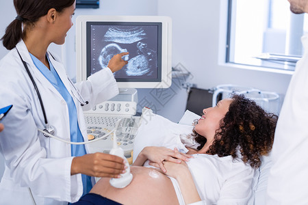 为孕妇进行超声波扫描的医生外套母性住院医院孕妇装孕产医疗互动怀孕女性背景图片