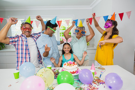 手绘气球派对帽多代人幸福家庭庆祝生日晚会的庆祝活动惊喜蜡烛童年母亲感情住所男人祖父男性混血背景