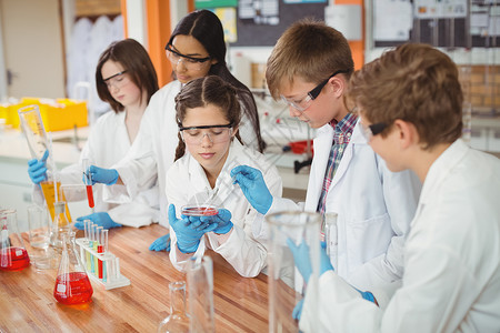 细心的学童在实验室做化学实验男生试验桌子孩子友谊知识教育化工防护眼镜橙子背景图片