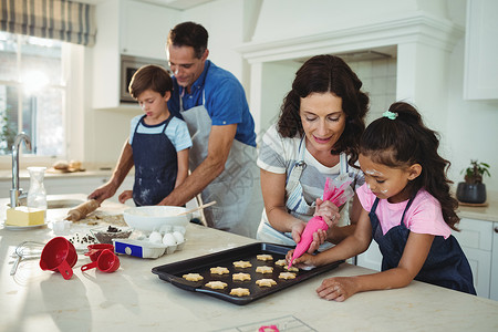 压片幸福的家庭在厨房做饼干面粉男性母亲家庭生活男生孩子装潢父亲滚动女孩背景