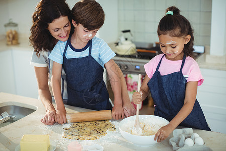 母亲和孩子在厨房做饼干公寓混血家庭生活黄油滚动准备台面压片亲密感女儿背景