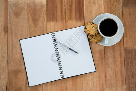 猴菇饼干带笔和黑咖啡的开放日记甜食检查螺旋桌子热饮饮料咖啡杯早餐办公室杯子背景