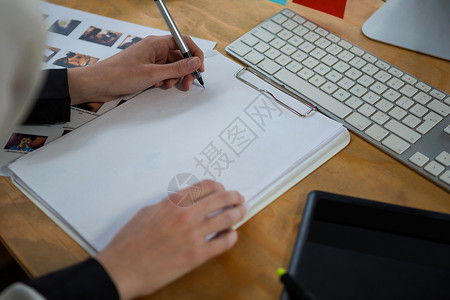 电脑制图在办公桌工作的女性制图设计师办公室笔记本创造力管理人员键盘平面设计师职场屏幕绘画文档背景