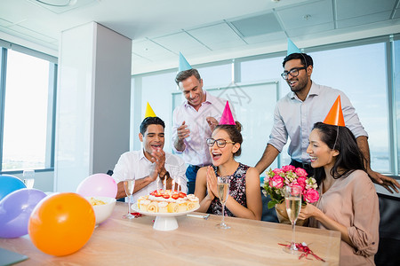 40岁生日欢庆妇女生日的微笑的同事们蛋糕架快乐工作男人职场糕点商业人士管理人员气球背景