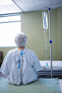 静脉滴注高级病人躺在床上的重新观察毯子药物治疗病号退休输液架疾病病房女士盐水智力背景