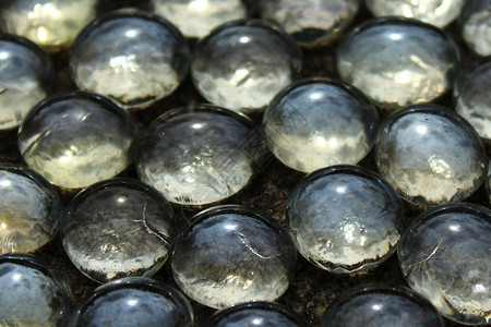 石地板上有许多玻璃珠子弹珠装饰玻璃珠背景图片