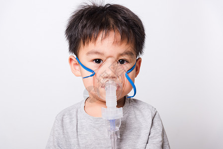 蒸汽吸入器近距离的亚洲脸孔 小男孩生病了 他用蒸汽水空气呼吸孩子们病人医院孩子面具男生药品药物背景