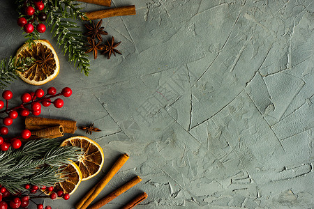下雪的圣诞卡圣诞卡概念灰色桌子乡村红色食物浆果香料平铺橙子肉桂背景