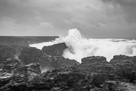 波浪黑金冰冰岛的布里姆克蒂尔熔岩岩池巨浪 以黑白和黑白形式冲击黑金山海岸背景
