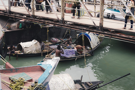 渔民坐在渡轮码头桥下的一艘渔船上 在冒险前往恒河捕鱼之前准备渔网 2020 年 3 月印度南亚太地区加尔各答城市生活背景图片