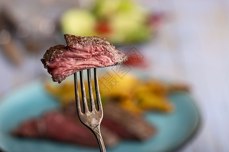 叉子上切片牛排古董牛肉乡村盘子薯条烹饪红色质量蒸汽食物背景图片