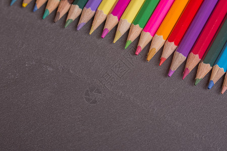 彩色铅笔成套绘画工具乐器彩虹锐化刨花艺术桌子锯末背景图片