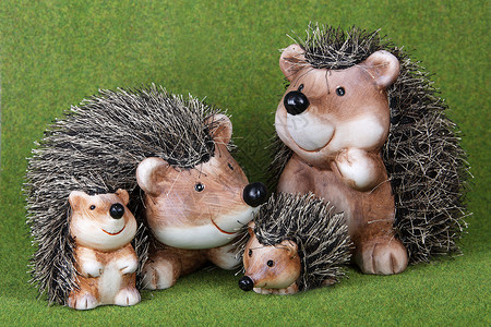 在草地上聚在一起的可爱玩具刺猪家族高清图片
