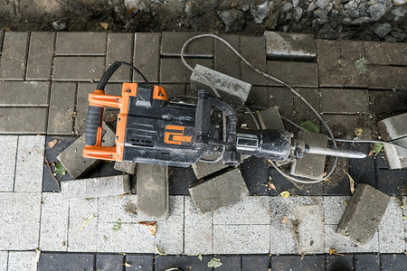 在人行道建筑工程期间 在科布斯通公路上铺设水泥断路器沥青工作服活动拆除粉碎建筑挖掘机男人机械锤子背景图片