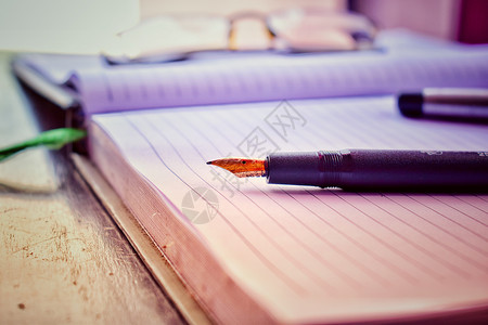 日记页上的钢笔 上面有帽子和眼镜高清图片