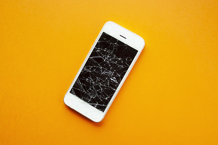 苹果手机碎屏橙色背景上智能手机的碎屏橙子服务商业维修裂缝屏幕技术失败细胞电脑背景