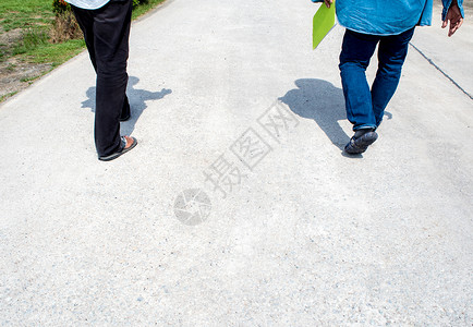 两个人的腿在走道上一起走路背景图片