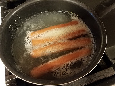 热狗在炉灶上沸锅中沸水小吃烹饪猪肉平底锅午餐火炉背景图片