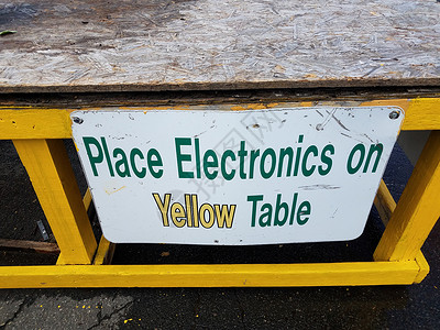 将电子设备安装在废铁场木板上的黄色桌牌上背景图片