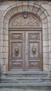 法式门 保存完好并修复 富有显着的主屋门雕刻橡木狮子上木钟和其他雕刻乐器 中世纪石框背景