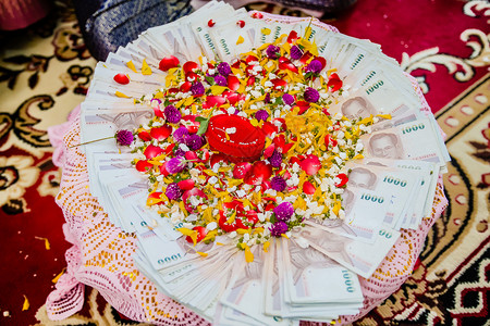 泰国传统婚礼花盘上的嫁妆钱家庭庆典订婚戒指花环仪式新娘金子托盘礼物背景图片