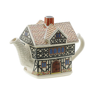 白色背景上的房子形茶壶与剪裁拍拍背景图片