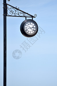 铁柱对着蓝天的钟背景图片