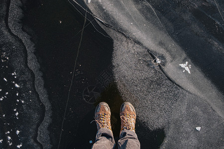 裂脚亚目站在薄冰上 顶层风景寒冷快照登山鞋蓝色清冰风险裂缝看法危险晴天背景