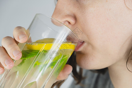 卡通柠檬薄荷水一杯柠檬饮料在人手手中 宿醉治疗 汤水薄荷产品配料水果食谱果汁玻璃摄影美食解酒背景