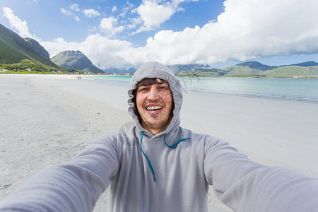 贝格拉姆在洛福顿岛的拉姆贝格斯特兰达海滩上做自拍的旅游者 美丽的沙滩和凉水 挪威场景海滩旅行港口晴天峡湾村庄爬坡游客微笑背景