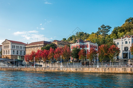 秋天在河边有树木的建筑物高清图片