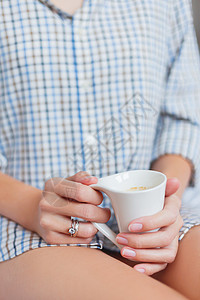 穿衬衫的女人坐在床上 端着一杯热咖啡 明亮的订婚戒指和结婚戒指在她的手指上闪闪发光 舒适的早晨在家咖啡宝石婚礼女孩钻石就寝时间饮背景图片