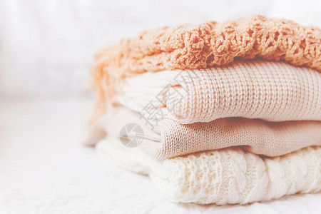 白色背景的蜜蜂羊毛衣皮质 暖湿编织的毛衣和围巾叠在一个堆中 仿佛Instagram风格的音调衣服褐色针织羊毛钩针织物乡村生态季节背景图片