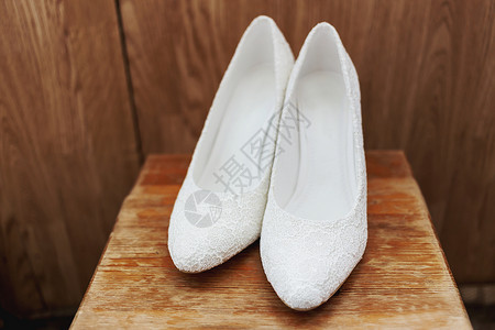 一双白带子的新娘鞋 传统的新娘从属品 难看的木头背景背景图片