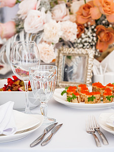用餐具和花瓶里的鲜花 做婚礼宴席的餐桌 面条彩色装饰品餐厅玻璃宴会盘子桌子餐巾作品派对咖啡店玫瑰背景图片