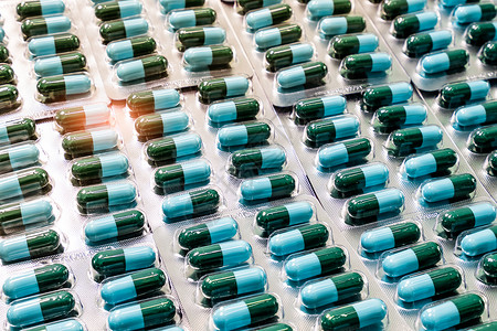 在泡罩包装的特写镜头绿蓝色抗生素胶囊药片 一个感染反抗产品水疱药店制药禁忌症服务药品技术背景图片