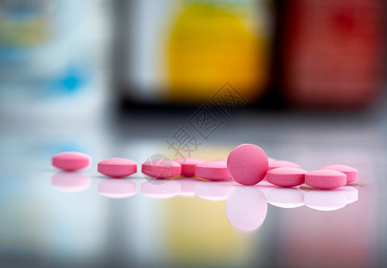 抗菌剂药物中药瓶模糊背景下的粉红色药丸背景