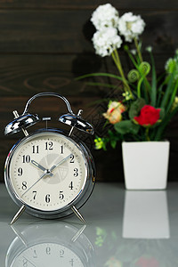 桌面上的闹钟和花花花瓶空白黑色花束桌子办公室礼物甲板饮料背景图片