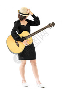 女人手里握着吉他吉他吉他民歌青少年成人吉他手白色帽子女性工作室乐器女孩女士背景图片
