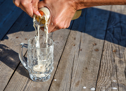 杯子杯 在公园的桌上放啤酒桌子琥珀色玻璃饮料酒精阳光气泡晴天金子太阳背景图片