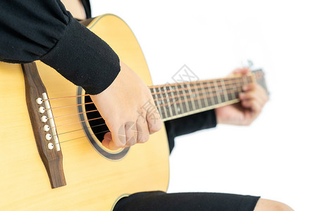 坐在她手里并弹吉他吉他民歌的妇女原声女士乐器音乐家青少年音乐帽子白色吉他手女孩背景图片