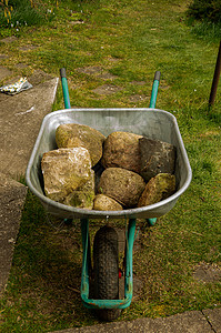 配有石头和重工的花园轮式手推车背景图片
