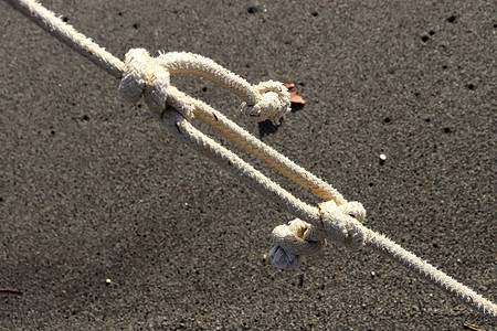 在沙子背景上打结的绳子 夏季海滩背景背景图片