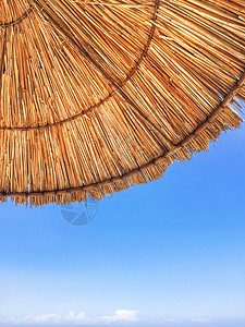 草滩雨伞底部的景色 清晰蓝天背景 假期 休息和放松的标志 土耳其凯默海滩晴天天空旅游稻草蓝色旅行背景图片